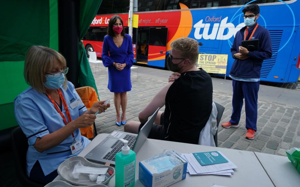 Scotland's deputy chief medical officer Dr Nicola Steedman watches as the public get their jabs by a vaccine bus - Andrew Milligan/PA Wire