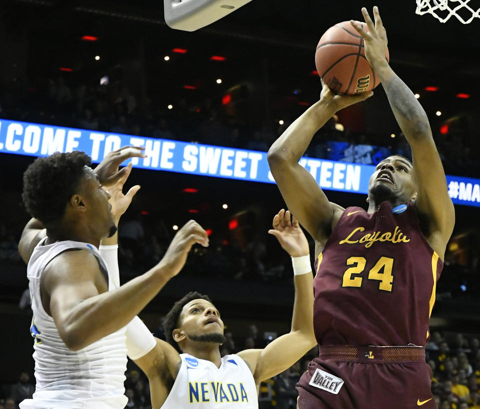 Loyola-Chicago forward Aundre Jackson (24) shoots against Nevada guard Jordan Caroline, left, and Nevada guard Hallice Cooke (13) during the first half. (AP Photo/John Amis)