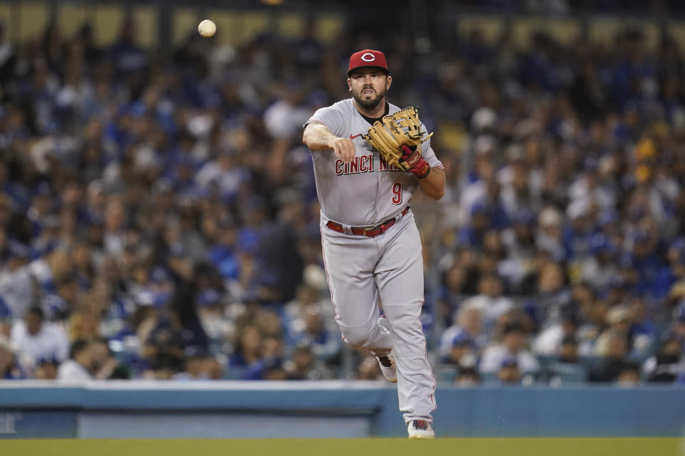 Cincinnati Reds third baseman Mike Moustakas (9) throws to first base to out Los Angeles Dodgers' Trea Turner during the third inning of a baseball game in Los Angeles, Thursday, April 14, 2022. (AP Photo/Ashley Landis)