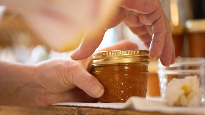 Person putting lid on jam jar