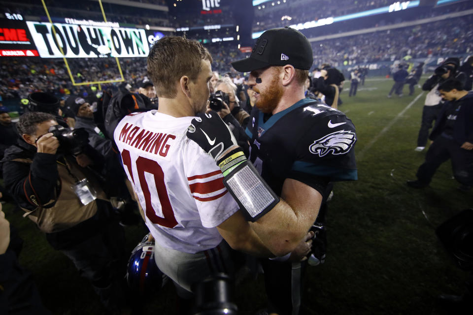 New York Giants' Eli Manning, left, and Philadelphia Eagles' Carson Wentz meet after overtime of an NFL football game, Monday, Dec. 9, 2019, in Philadelphia. (AP Photo/Matt Rourke)