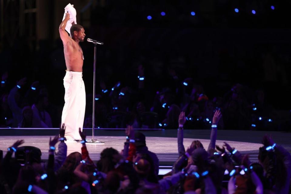 Usher takes off his shirt during the halftime show.