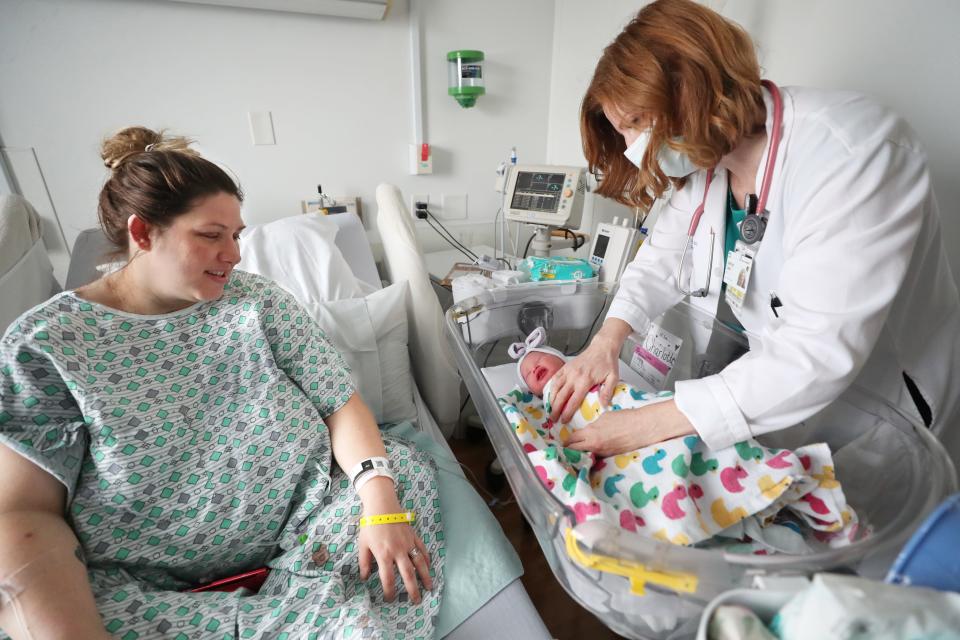 Brittany Long watches as Dr. Katie Clark, a family medicine resident, swaddles her newborn daughter, Charlotte, on the Mother Baby Unit at Cleveland Clinic Akron General.