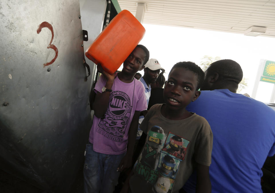 A boy carries a tank of gas as he leaves a gas station in Port-au-Prince, Tuesday, July 13, 2021, almost a week after President Jovenel Moise was assassinated in his home. (AP Photo/Fernando Llano)