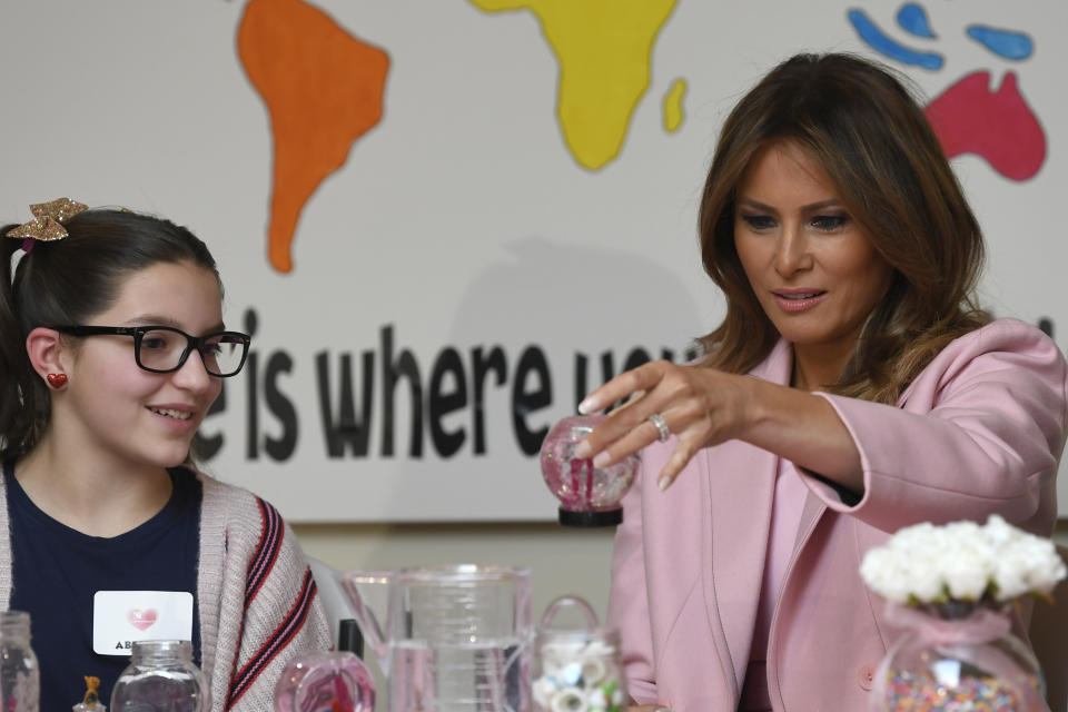 First lady Melania Trump, right, looks at her handmade snow globe as she sits next to Abigail, left, during a visit to the National Institutes of Health to see children at the Children's Inn in Bethesda, Md., Thursday, Feb. 14, 2019, to celebrate Valentine's Day. (AP Photo/Susan Walsh)