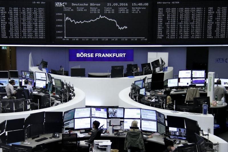 Traders work at their desks in front of the German share price index, DAX board, at the stock exchange in Frankfurt, Germany, September 21, 2016. REUTERS/Staff/Remote