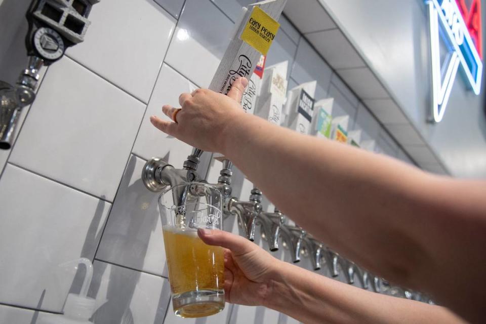 A bartender pours a pint of City Barrel’s Easy Peasy Lemon Squeezy, a lemon dry-hopped kolsch.