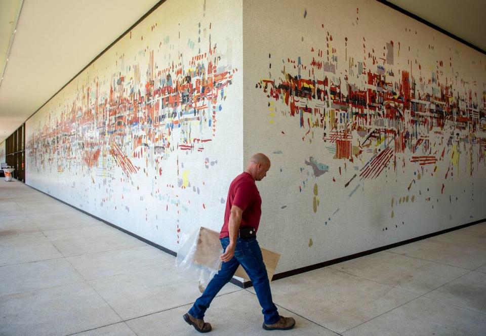 A SMUD employee walks past “Water City,” an abstract mosaic mural by Wayne Thiebaud, at the historic SMUD headquarters building in Sacramento in 2019, after the mural was been cleaned and restored as part of the renovation of iconic building.