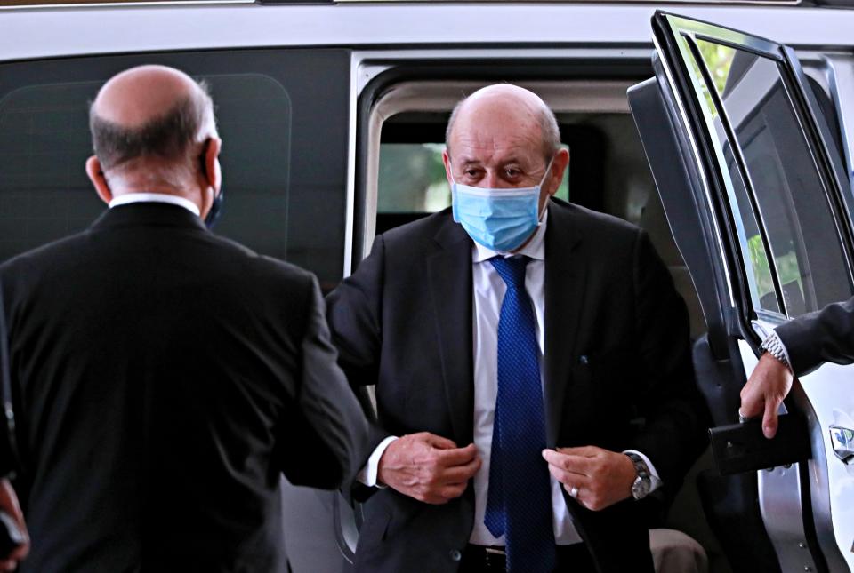 French Foreign Minister Jean-Yves Le Drian, right, wearing a mask to help prevent the spread of the coronavirus, arrives to meet his Iraqi counterpart Fouad Hussein, left, in Baghdad, Iraq, Thursday, July 16, 2020. (AP Photo/Hadi Mizban)