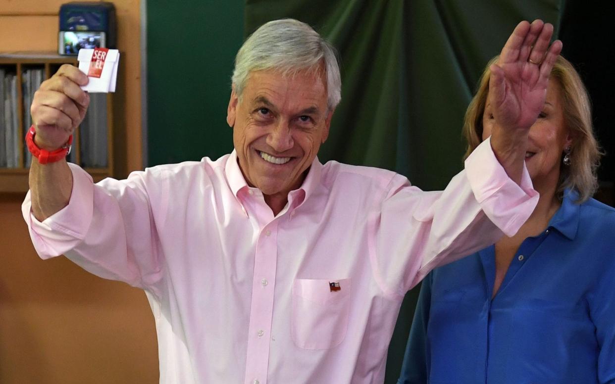 Sebastian Pinera, pictured casting his vote earlier in the day, won the election - AFP