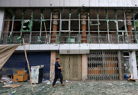 An Afghan man walks past a damaged building at the site of blasts in Jalalabad city, Afghanistan May 13, 2018. REUTERS/Parwiz