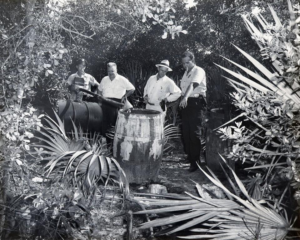 This photograph by long-time Beaches photographer Virgil Deane shows government agents investigating a moonshine still in Palm Valley.