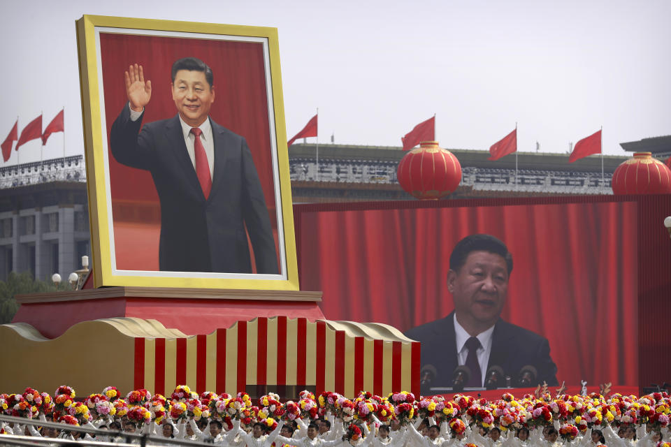 FILE - In this Tuesday, Oct. 1, 2019 file photo, participants cheer beneath a large portrait of Chinese President Xi Jinping during a parade to commemorate the 70th anniversary of the founding of Communist China in Beijing. (AP Photo/Mark Schiefelbein, File)