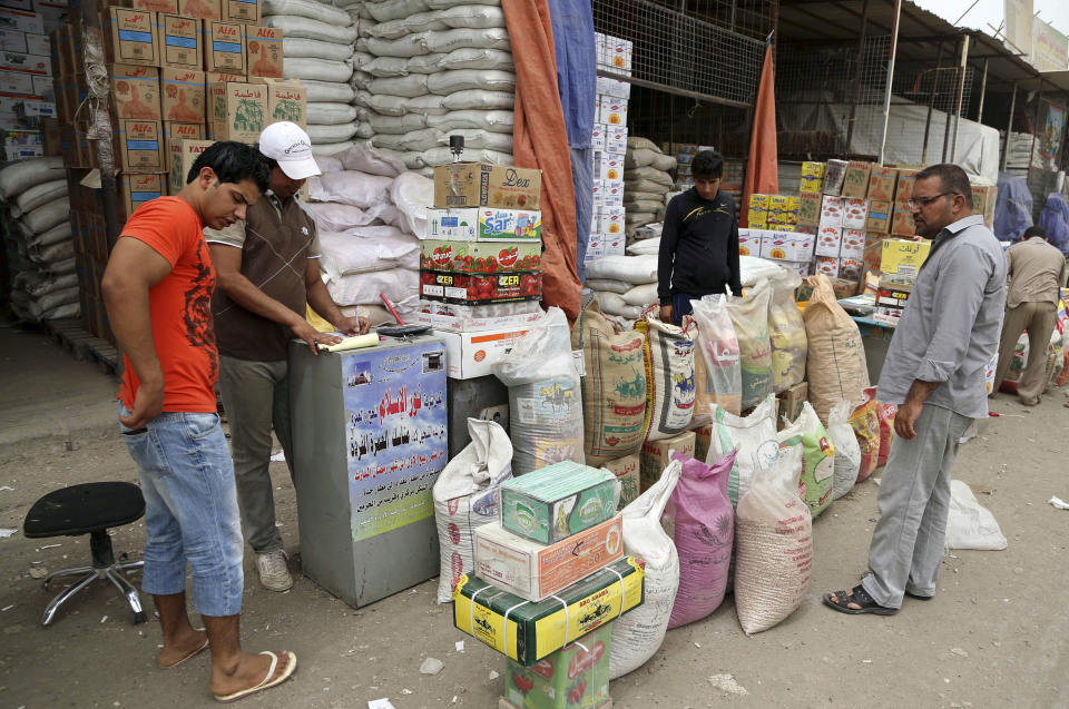 In this photo taken Friday, May 9, 2014, shoppers buy goods in Jamila market in Baghdad, Iraq. Fighting in Iraq’s western Anbar province, now in its fifth month, appears to have bogged down, with government forces unable to drive out Islamic militants who took over one of the area’s main cities. But the impact is being felt much further, with the repercussions rippling through the country’s economy to hit consumers and businesses. Fighting has also disrupted shipping, inflating prices of goods in Baghdad and elsewhere. (AP Photo/ Karim Kadim)