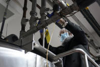 Rabbi Mendel Einhorn uses zip ties to prevent any contamination while helping Hanan Products prepare their factory for the kosher-for-passover production run, Thursday, Jan. 7, 2021, in Hicksville, N.Y. (AP Photo/Seth Wenig)