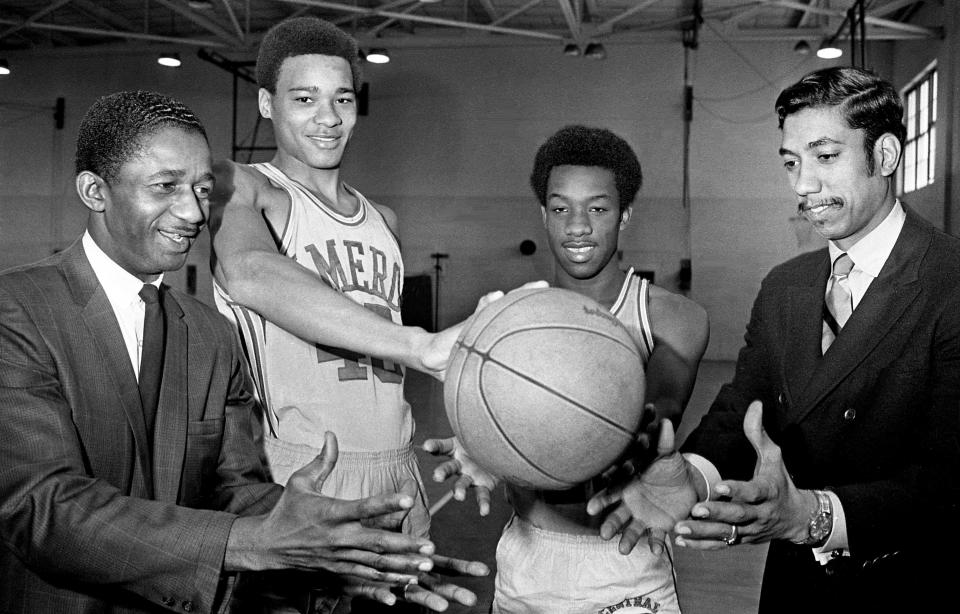 Cameron High 6-8 center David Vaughn, second from left, holds the basketball out for Marques Haynes, left, of the Harlem Magicians, teammate Cecil Beard and coach Ronnie Lawson at the school Jan. 20, 1970. The four will all be involved in a tripleheader Jan. 24 at Municipal Auditorium. Cameron and Gallatin play first, then the Magicians take on the New York Rens and Pearl battles Maplewood in the final game.