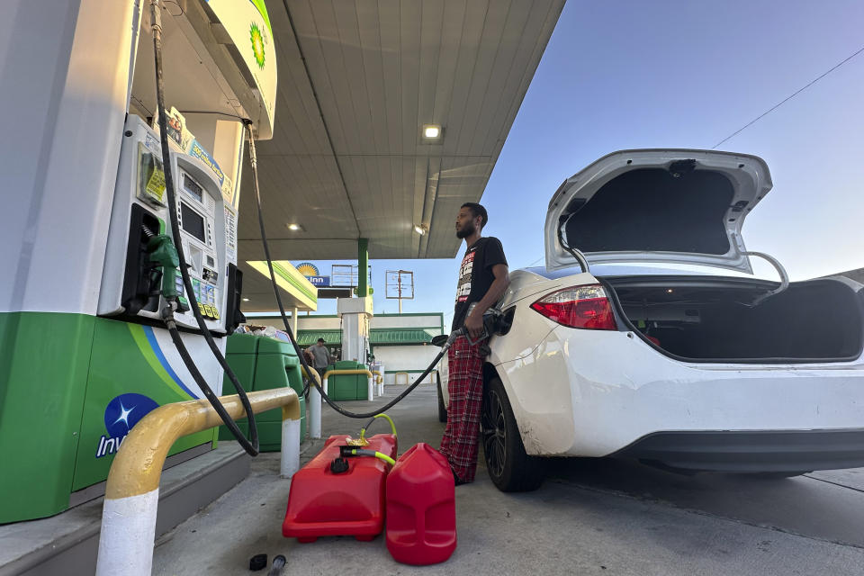 Chae Tillman fills fuel containers at a gas station in the aftermath of Hurricane Helene on Saturday, Sept 28, 2024 in Adell, Ga. (AP Photo/Mike Stewart)