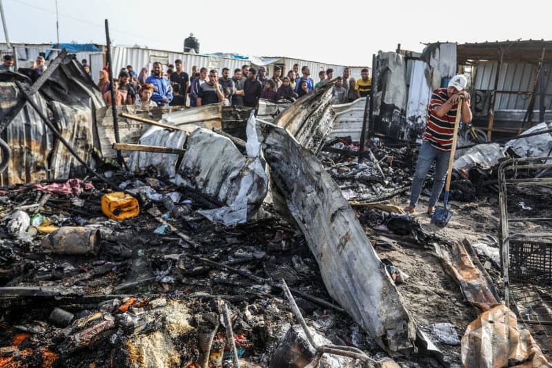 Palestinians inspect their destroyed tents after an Israeli air strike, which resulted in numerous deaths and  injuries, in the Al-Mawasi area, which was bombed with a number of missiles on the tents of displaced people west of the city of Rafah in the southern Gaza Strip. Abed Rahim Khatib/dpa