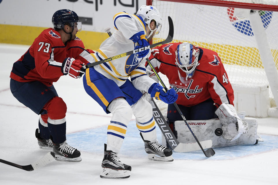 Washington Capitals goaltender Vitek Vanecek (41) stops the puck against Buffalo Sabres left wing Taylor Hall, center, during the first period of an NHL hockey game, Friday, Jan. 22, 2021, in Washington. Capitals left wing Conor Sheary (73) looks on. (AP Photo/Nick Wass)