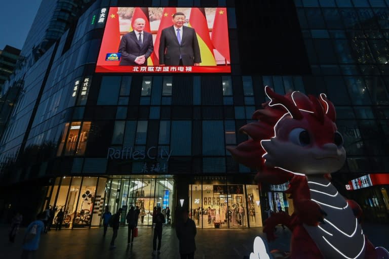 Scholz und Xi auf einer Nachrichtenanzeige in Peking (Pedro PARDO)