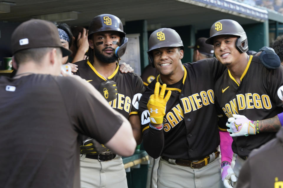 San Diego Padres' Manny Machado, right, celebrates his three-run home run with Fernando Tatis Jr., left, and Juan Soto by having their picture made by a teammate against the Detroit Tigers in the third inning of a baseball game, Saturday, July 22, 2023, in Detroit. (AP Photo/Paul Sancya)