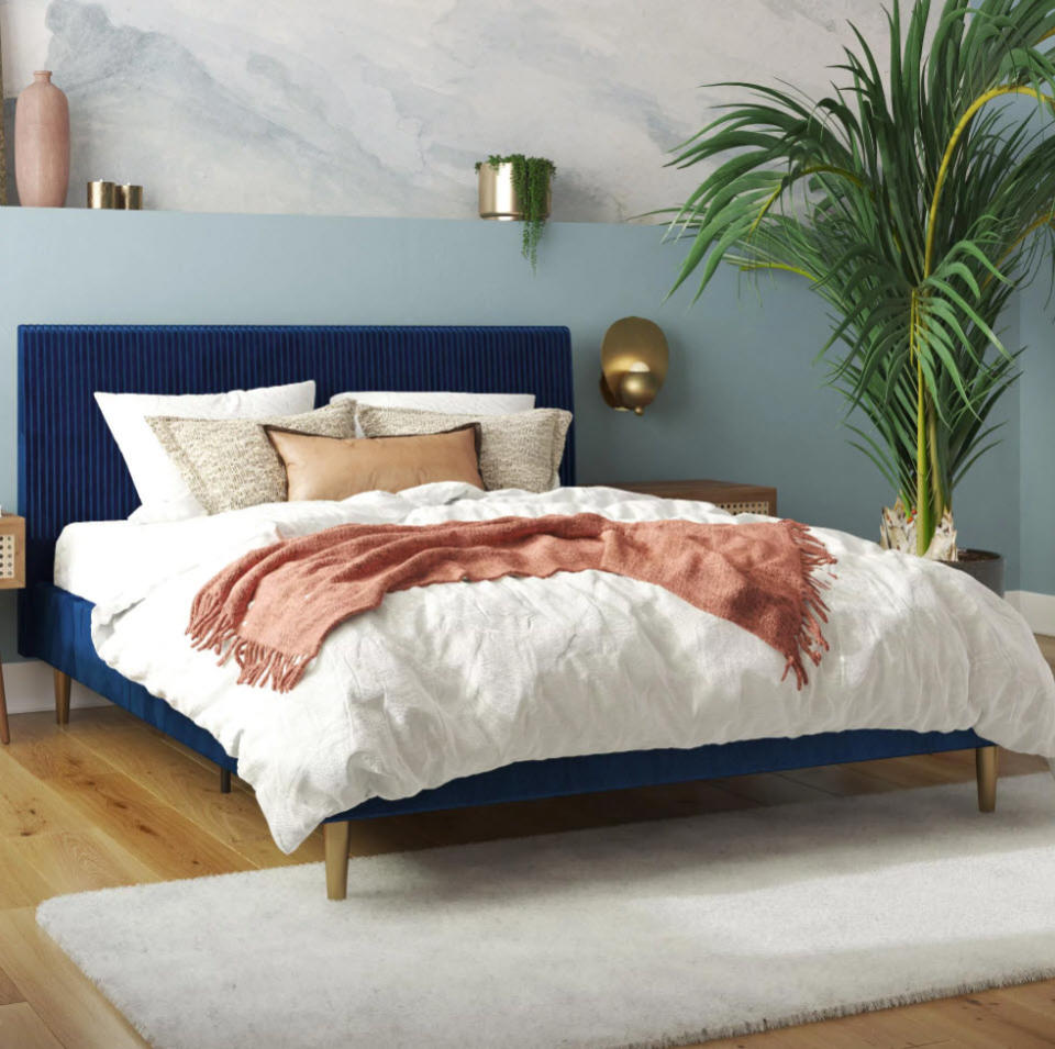 dark blue velvet headboard and bed frame in bedroom