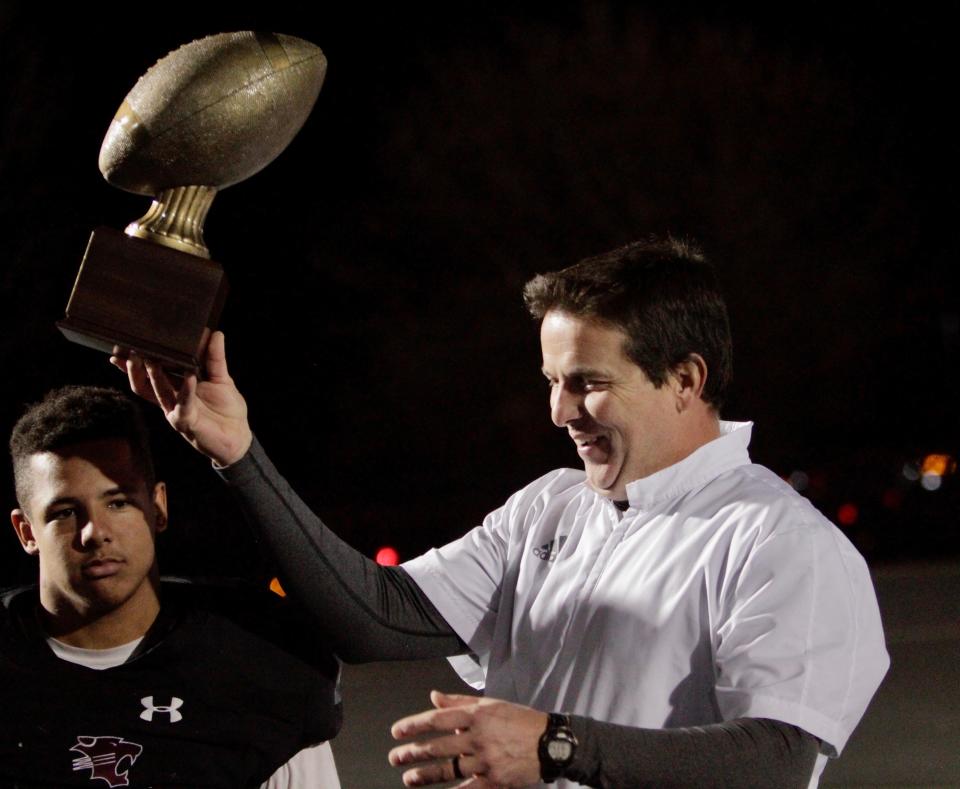 Hawley head coach Mitch Ables lifts the gold ball trophy after beating Marlin on Dec. 9. Ables led Hawley to the 2A Division I state championship game.