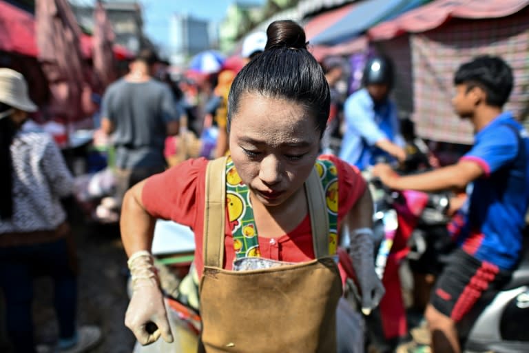 Una comerciantes suda mientras arrastra un carro en el Mercado Khlong Toei de Bangkok el 25 de abril de 2024 (Manan Vatsyayana)