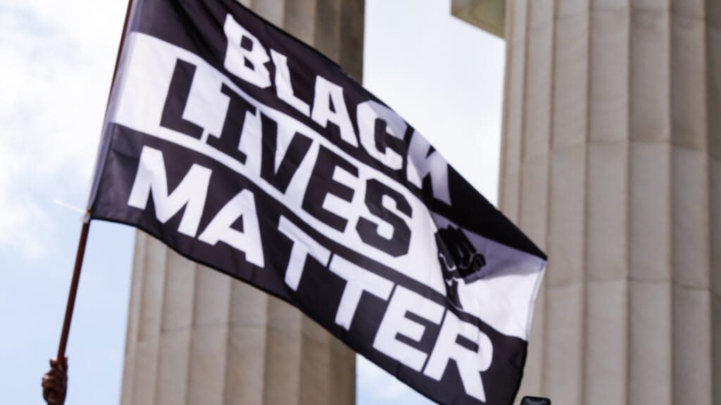 A demonstrator waves a flag in support of Black Lives Matter during last month’s Commitment March at the Lincoln Memorial in Washington, D.C. (Photo by Natasha Moustache/Getty Images)