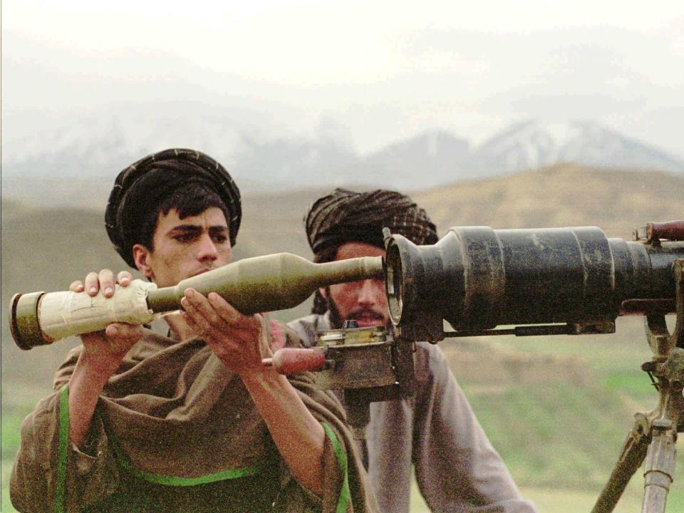 A Taliban fighter loads an artillery cannon.