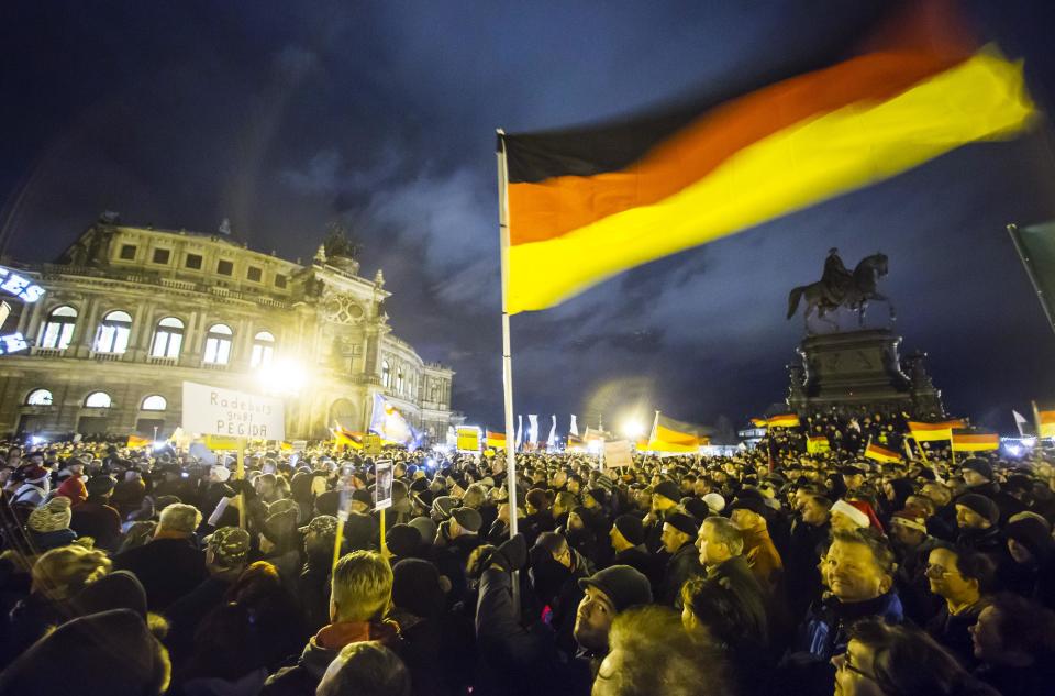 Participants hold German national flags during a demonstration organised by anti-immigration group PEGIDA in Dresden
