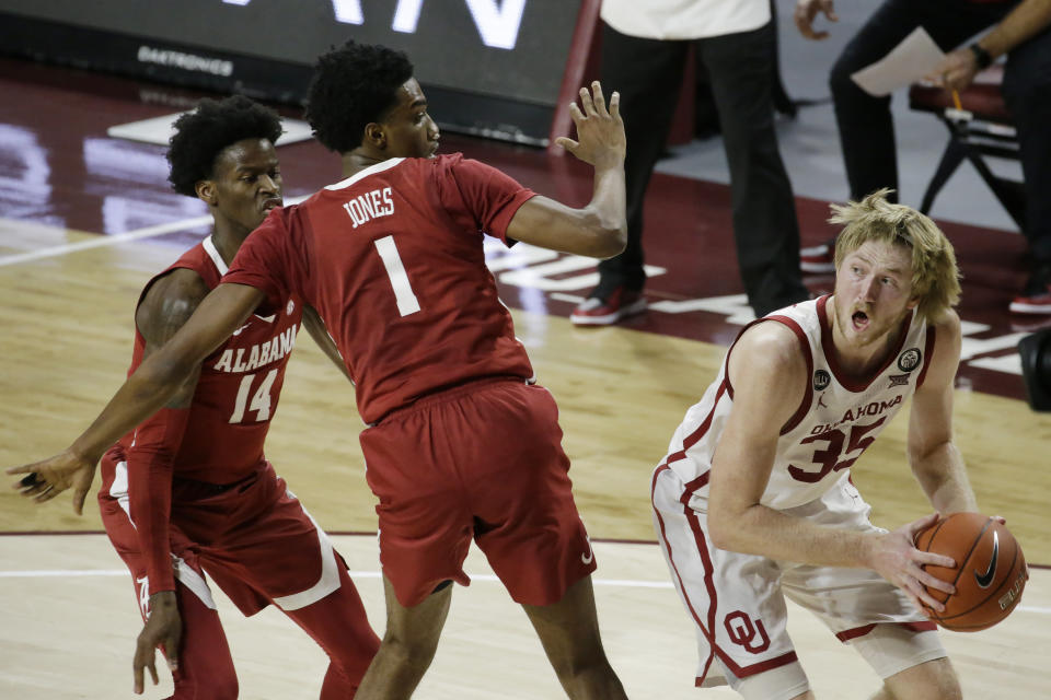 Brady Manek (35) looks to shoot against Alabama's Herbert Jones (1) and Keon Ellis (14) during the second half of an NCAA college basketball game in Norman, Okla., Saturday, Jan. 30, 2021. (AP Photo/Garett Fisbeck)