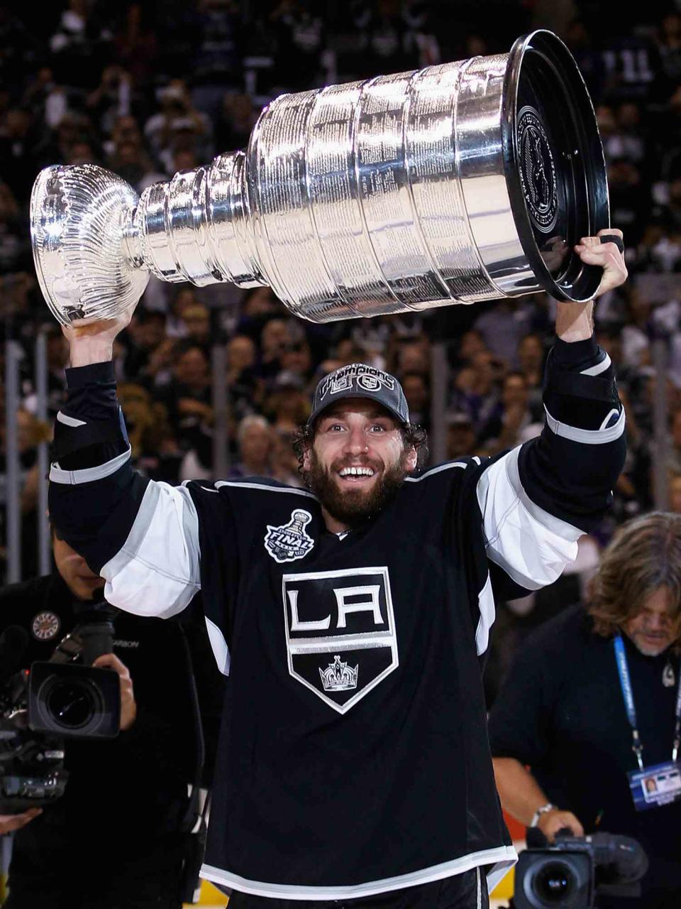 Jarrett Stoll #28 of the Los Angeles Kings holds up the Stanley Cup after the Kings defeated the New Jersey Devils 6-1 to win the Stanley Cup series 4-2 in Game Six of the 2012 Stanley Cup Final at Staples Center on June 11, 2012 in Los Angeles, California