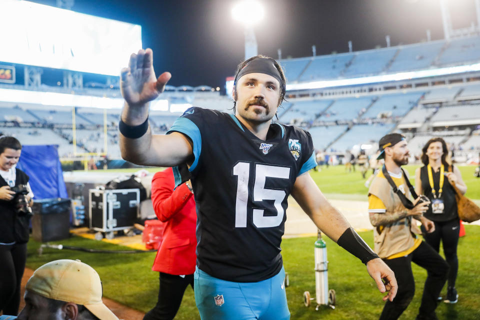 Gardner Minshew offers a high-five on the football field.