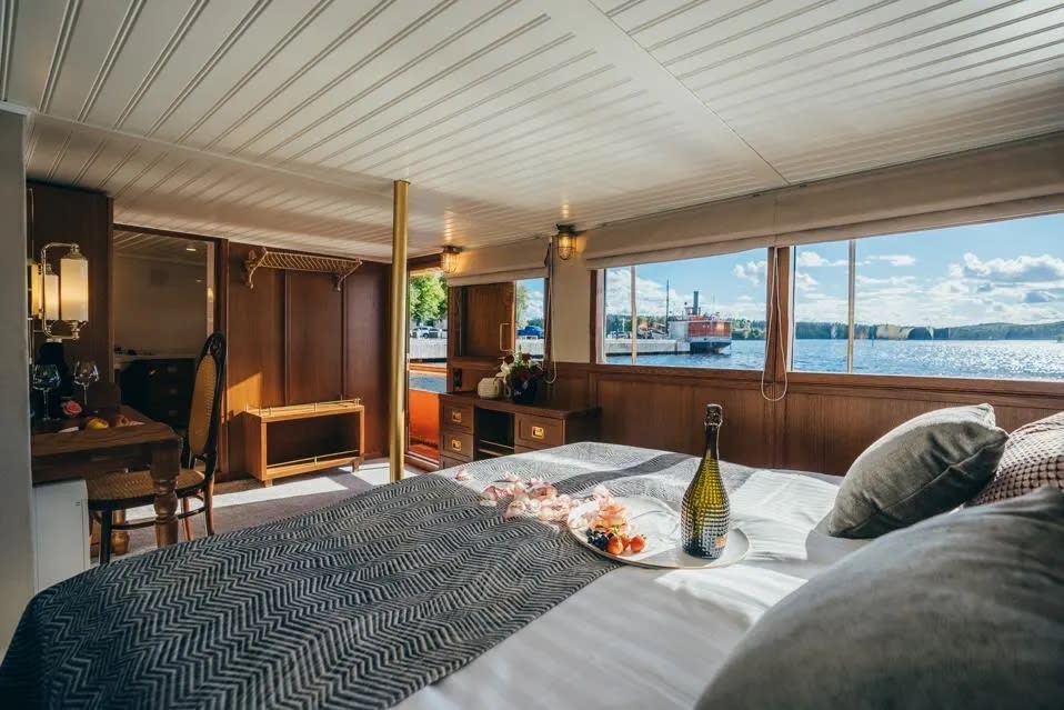 The suite on the S/S Paul Wahl features cozy bed, brass pole, writing desk, and antique sconces.