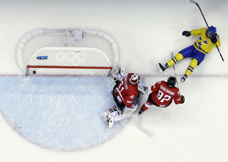 Michelle Lowenhielm of Sweden (28) reacts after scoring a goal past goalkeeper Florence Schelling of Switzerland (41) during the women's bronze medal ice hockey game at the 2014 Winter Olympics, Thursday, Feb. 20, 2014, in Sochi, Russia. (AP Photo/David J. Phillip )