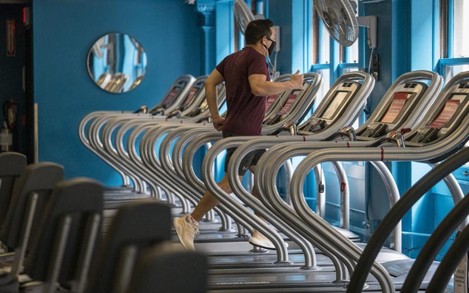 A person wearing a protective mask exercises at a Crunch Fitness gym location in San Francisco, California, U.S., on Thursday, Sept. 17, 2020. - David Paul Morris/Bloomberg