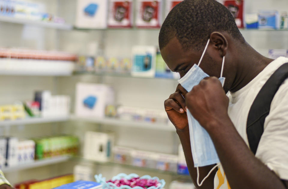 In this Feb. 6, 2020, photo, a man tries on a face mask at a pharmacy in Kitwe, Zambia. The coronavirus that has spread through much of China has yet to be diagnosed in Africa, but global health authorities are increasingly worried about the threat as health workers on the ground warn they are not ready to handle an outbreak. (AP Photo/Emmanuel Mwiche)