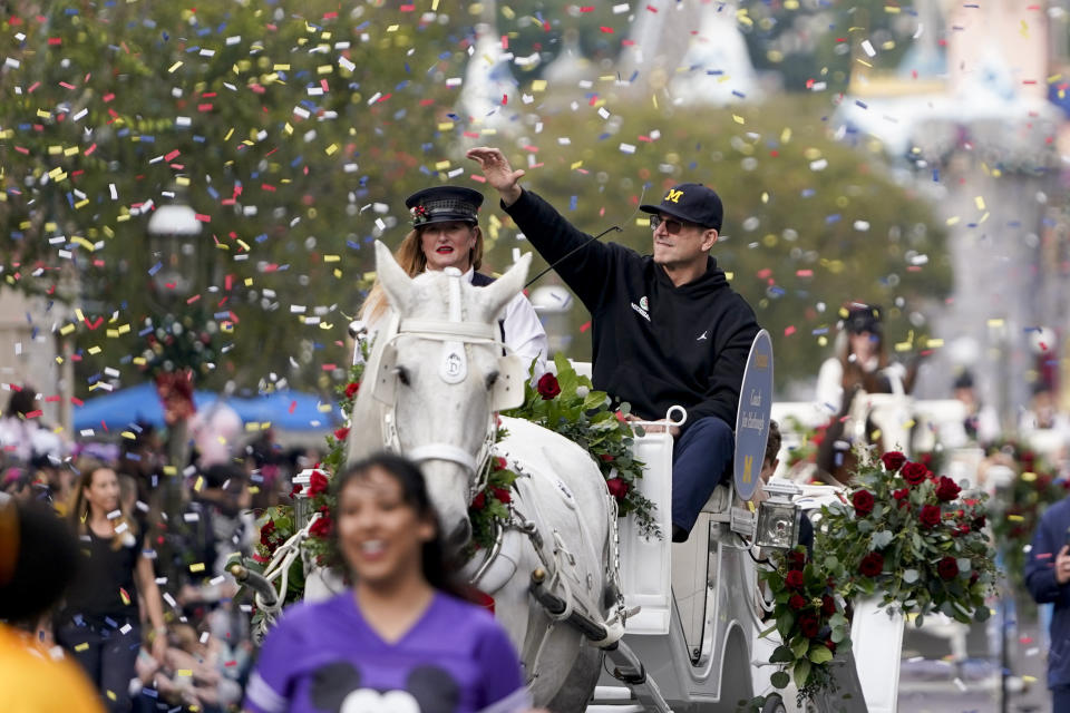 Michigan coach Jim Harbaugh waves during a welcome event for the team at Disneyland on Wednesday, Dec. 27, 2023, in Anaheim, Calif. Michigan is scheduled to play against Alabama on New Year's Day in the Rose Bowl, a semifinal in the College Football Playoff. (AP Photo/Ryan Sun)