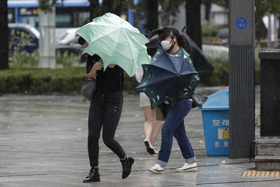 People struggle with their umbrellas against strong wind and rain in downtown Seoul, South Korea, Thursday, Sept. 3, 2020. A powerful typhoon ripped through South Korea’s southern and eastern coasts with tree-snapping winds and flooding rains Thursday, knocking out power to thousands of homes. (AP Photo/Lee Jin-man)