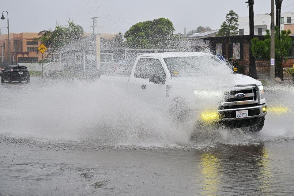 A vehicle crosses a flooded intersection in Imperial Beach, California on August 20, 2023.