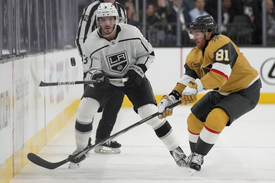 Los Angeles Kings defenseman Matt Roy (3) knocks the puck up the ice against Vegas Golden Knights right wing Jonathan Marchessault (81) during the first period of an NHL hockey game Wednesday, Nov. 8, 2023, in Las Vegas. (AP Photo/John Locher)