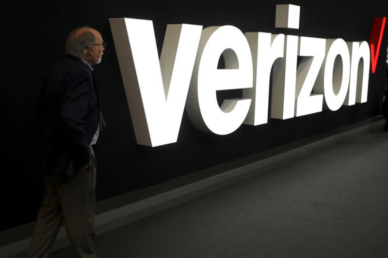 FILE PHOTO: A man stands next to the logo of Verizon at the Mobile World Congress in Barcelona