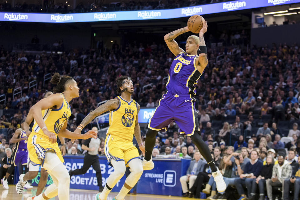 Los Angeles Lakers forward Kyle Kuzma (0) passes as Golden State Warriors forward Marquese Chriss (32) and guard Jordan Poole (3) watch in the first half of an NBA basketball game in San Francisco Saturday, Feb. 8, 2020. (AP Photo/John Hefti)