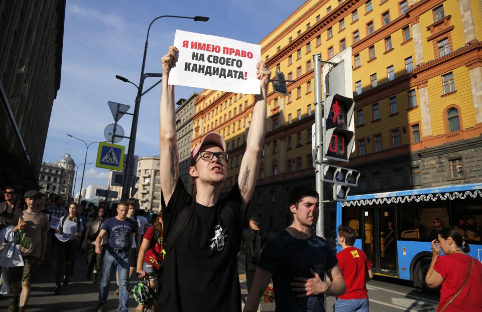 A protester holds poster that reads: "I have the right to my candidate" with the building of the Federal Security Service (FSB, Soviet KGB successor) in the background right, during an unsanctioned rally in the center of Moscow, Russia, Saturday, July 27, 2019. Russian police are wrestling with demonstrators and have arrested hundreds in central Moscow during a protest demanding that opposition candidates be allowed to run for the Moscow city council. (AP Photo/Alexander Zemlianichenko)