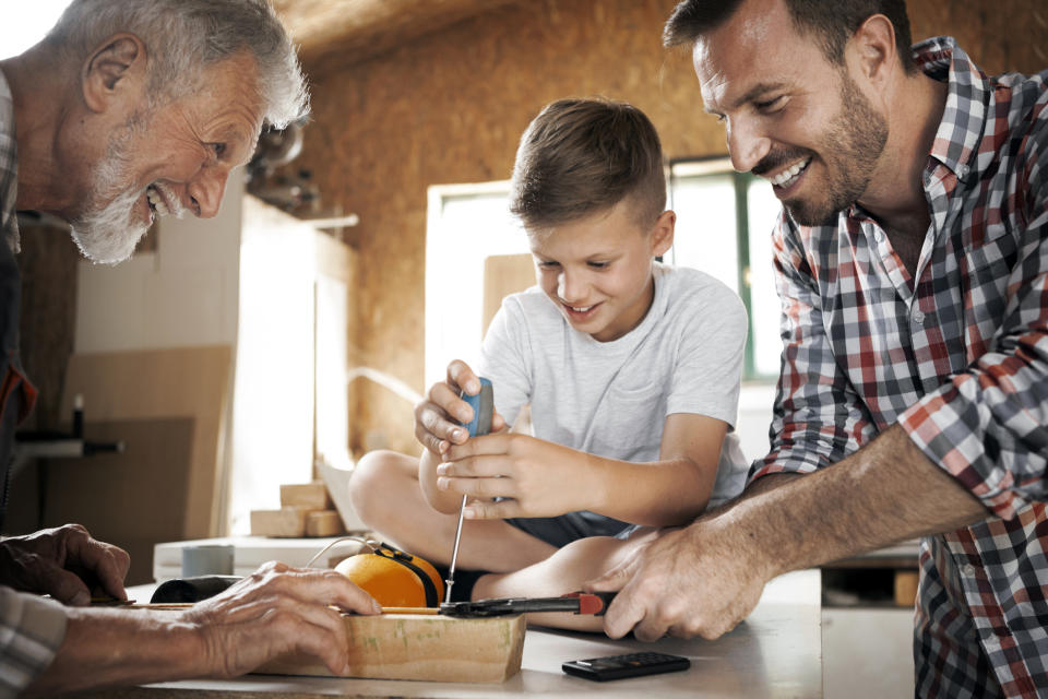 Grandfather ,father and son working at workshop screwing a screw