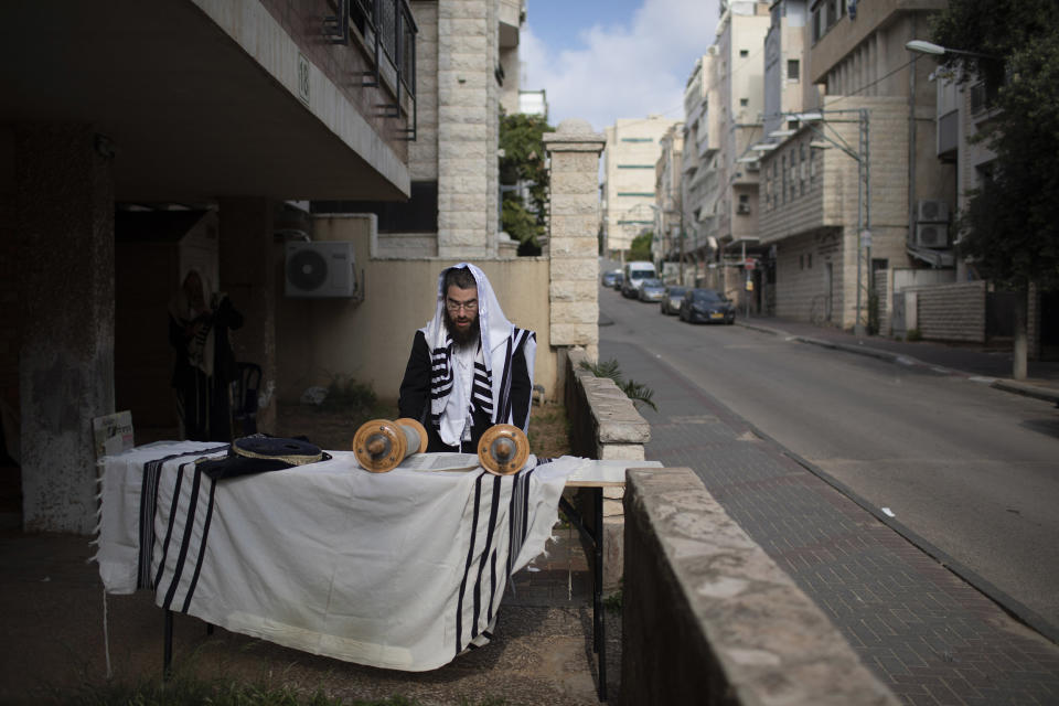 Image: An Ultra-Orthodox Jew prays a morning prayer next to his house as synagogues are closed following the government's measures to help stop the spread of the coronavirus, in Bnei Brak (Oded Balilty / AP)
