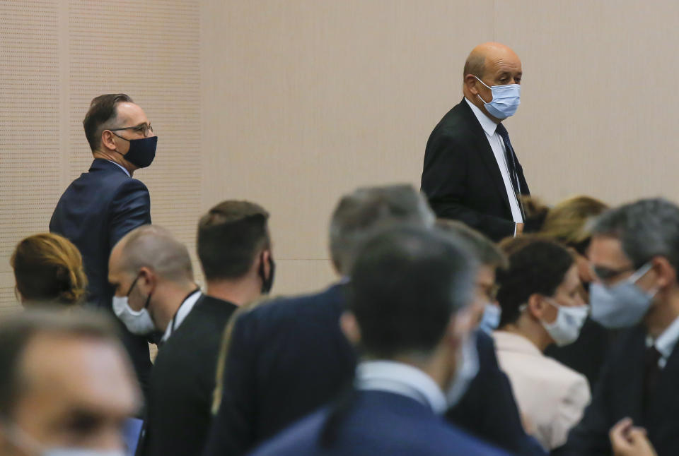 German Foreign Minister Heiko Maas, left, and French Foreign Minister Jean-Yves Le Drian wearing masks arrive for the opening session of the French ambassadors to European countries in Paris, Monday, Aug. 31, 2020. (AP Photo/Michel Euler)