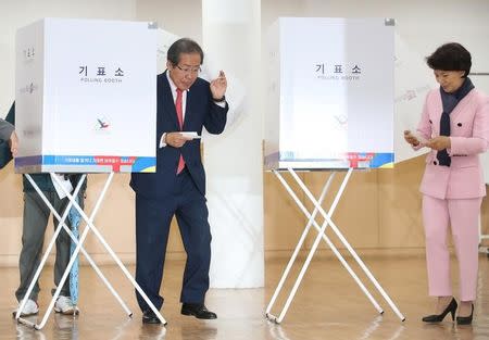 Hong Joon-pyo, the presidential candidate of the Liberty Korea Party, and his wife Lee Sun-sam walk to cast their ballots at a polling station in Seoul, South Korea, 09 May 2017, as voting began across South Korea for a presidential election. Lim Heun-Jung/Yonhap/via REUTERS