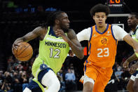 Minnesota Timberwolves forward Taurean Prince (12) drives as Phoenix Suns forward Cameron Johnson (23) defends during the first half of an NBA basketball game, Friday, Jan. 28, 2022, in Phoenix. (AP Photo/Matt York)